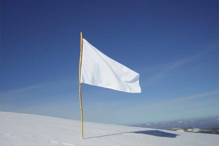 A white flag planted in snow.