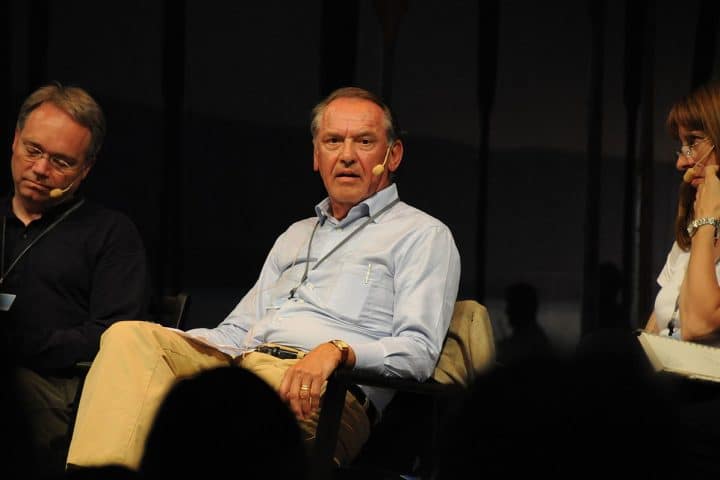 Jan Eliasson sitter på en scen bredvid två andra människor och talar.