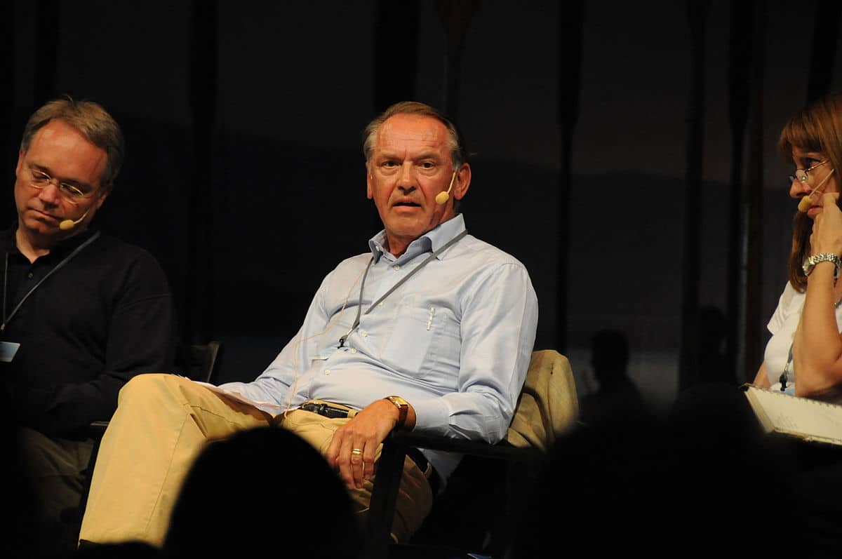 Jan Eliasson sitter på en scen bredvid två andra människor och talar.