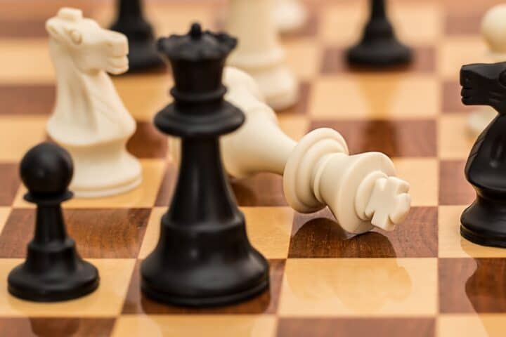 A chessboard with black and white pieces, with the white king knocked over.