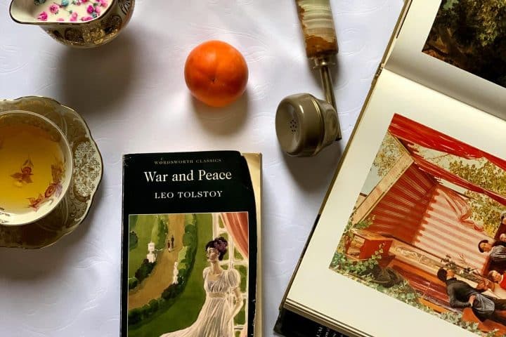 Antique items on a white table, including the book "War and Peace" by Leo Tolstoy.