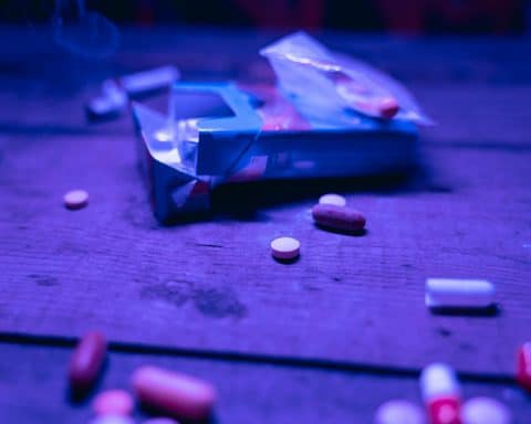 An mix of pills on a wooden table.