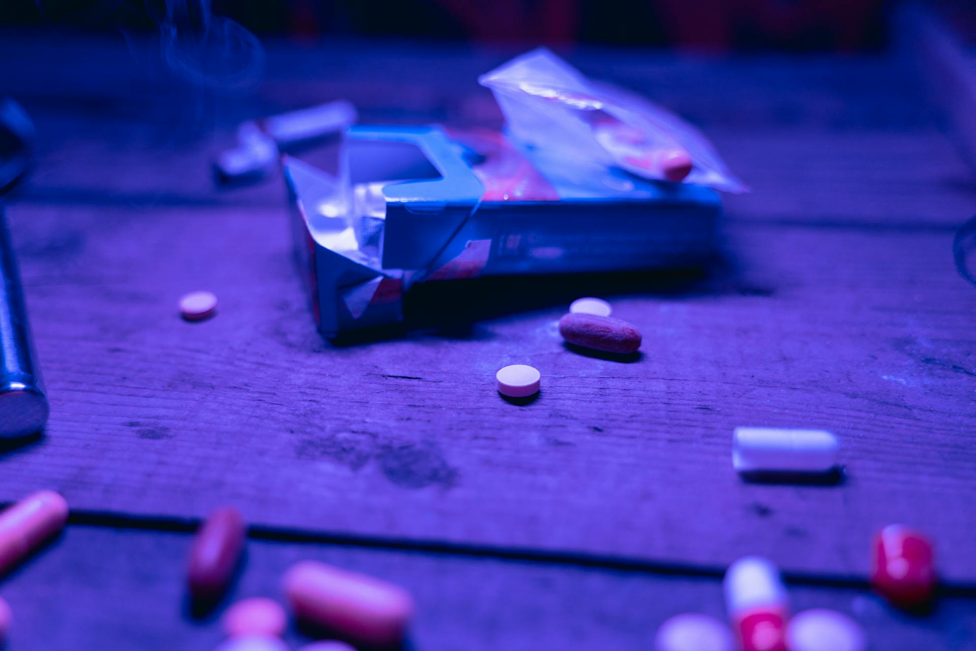 An mix of pills on a wooden table.