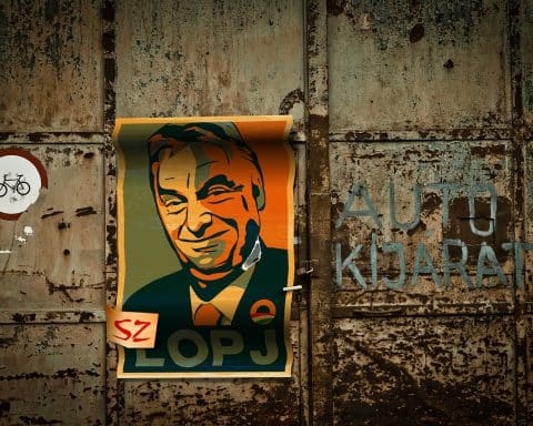 A poster of Viktor Orbán on a rusty garage door.