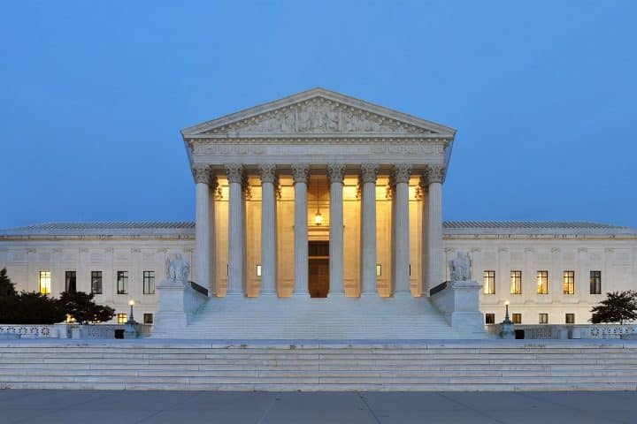 A panorama of the United States Supreme Court Building, in Washington DC. Its perfect geometry and marble pillars showcases its homage to classical Greek architecture.