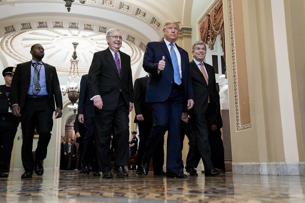 President Donald Trump walks down the halls of the U.S. Capitol alongside many colleagues, including Vice President Mike Pence and Senate Leader Mitch McConnell. The photo is from March 2020.