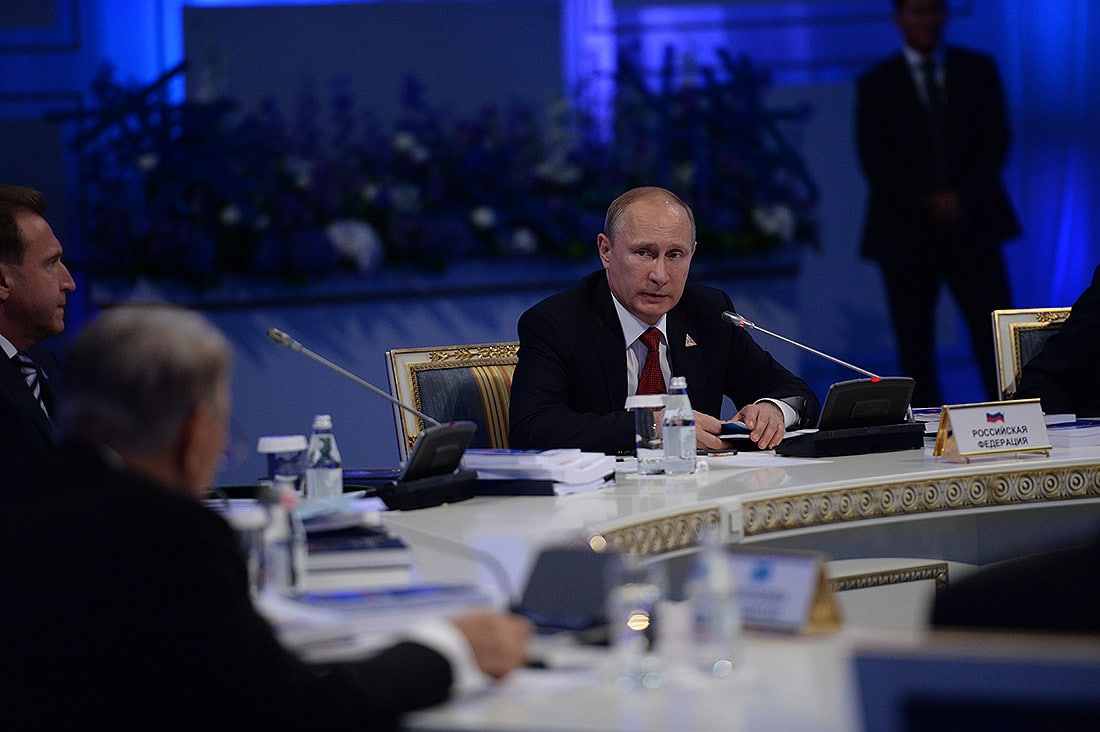 Vladimir Putin in a meeting with the other heads of state of the Eurasian Economic Union in Astana. He sits at a circular table.