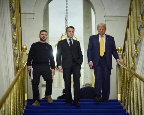 President-elect Donald Trump walking down a staircase alongside President Emmanuel Macron and President Volodymyr Zelenskyy.