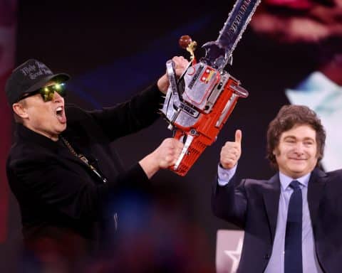 Elon Musk holding a chainsaw, with Javier Milei giving a thumbs up behind him.
