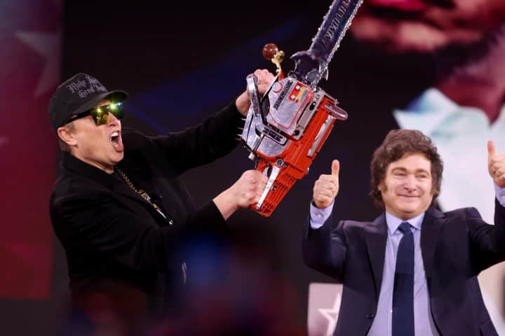 Elon Musk holding a chainsaw, with Javier Milei giving a thumbs up behind him.