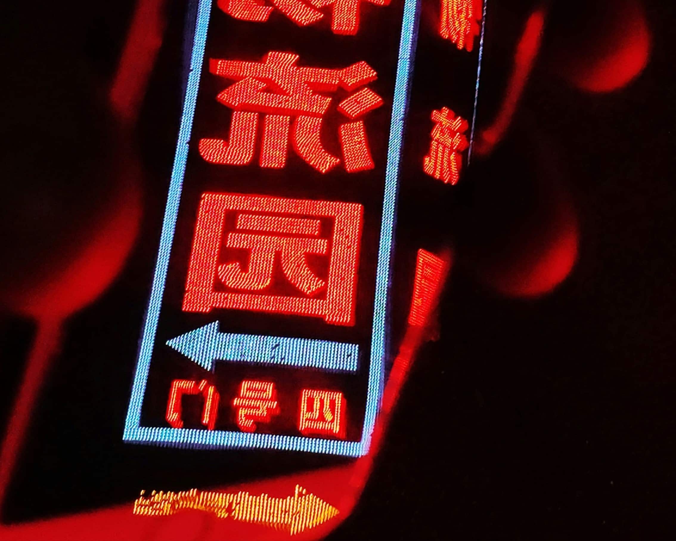 Red Chinese text reflected in an iPhone.