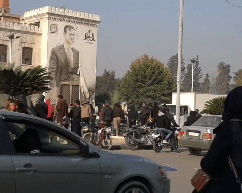 A wall with the imagery of Assad has been riddled with bullets.