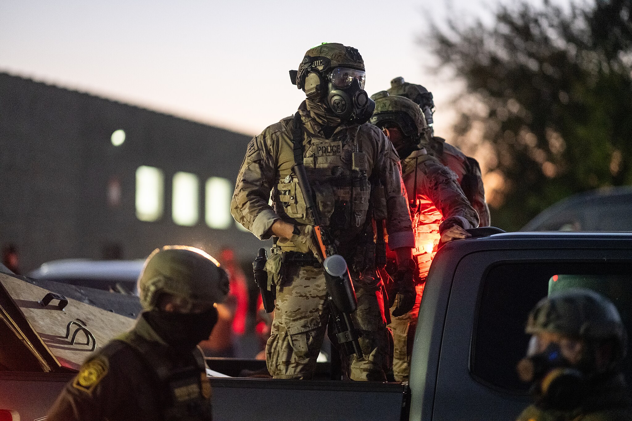 Armed police standing on a pickup truck.