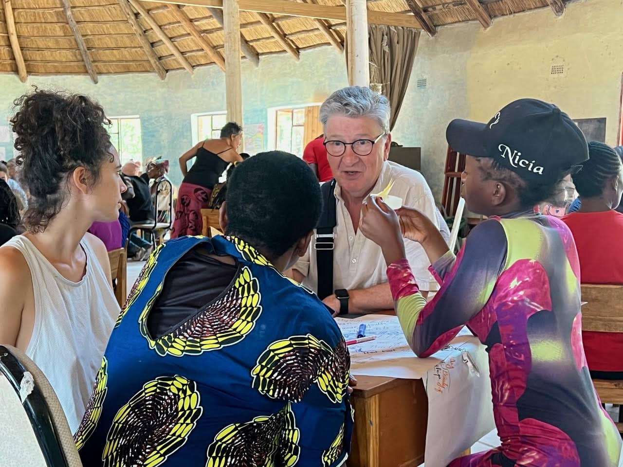Peace activist Toke Moeller speaking to people at a table indoors.